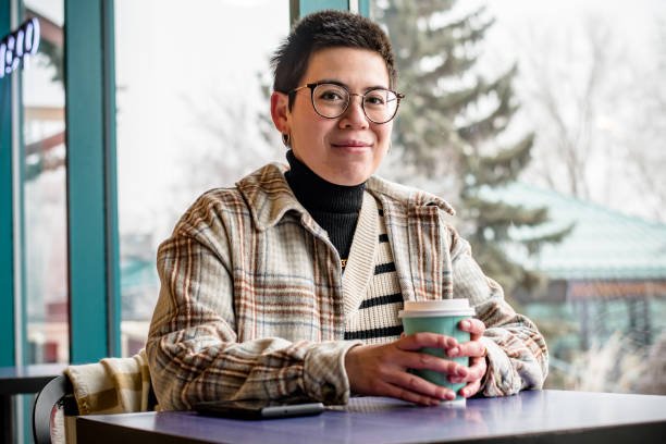 In an aura of café elegance, a close-up captures a non-binary professional with autism and ADHD, savoring a cup of coffee, creating a moment of blissful indulgence in the soothing atmosphere