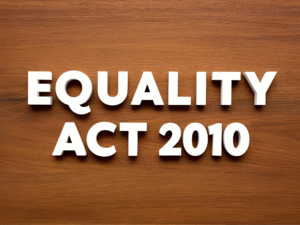 "Text reading 'Equality Act 2010' in bold white letters on a wooden background.