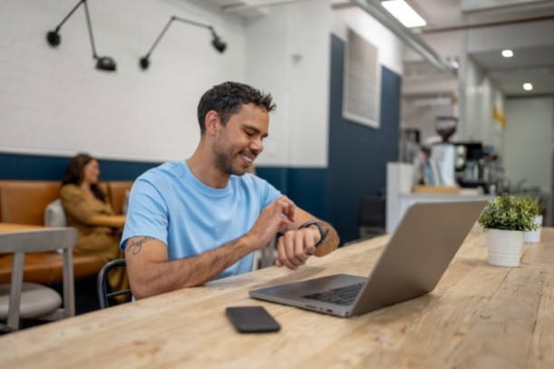 This image showcases modern technology enabling efficient multitasking in a relaxed cafe setting, reflecting the adaptability and convenience of remote work.