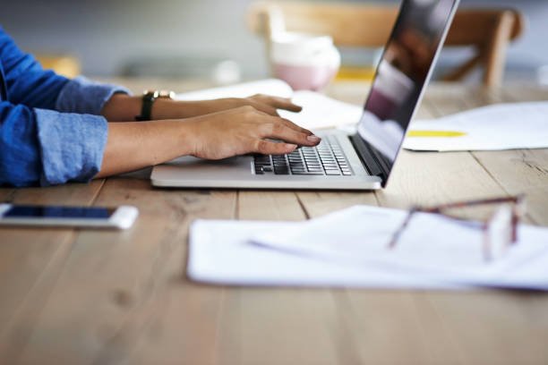 Cropped shot of a woman using a laptop while working from home to contact forward focus training